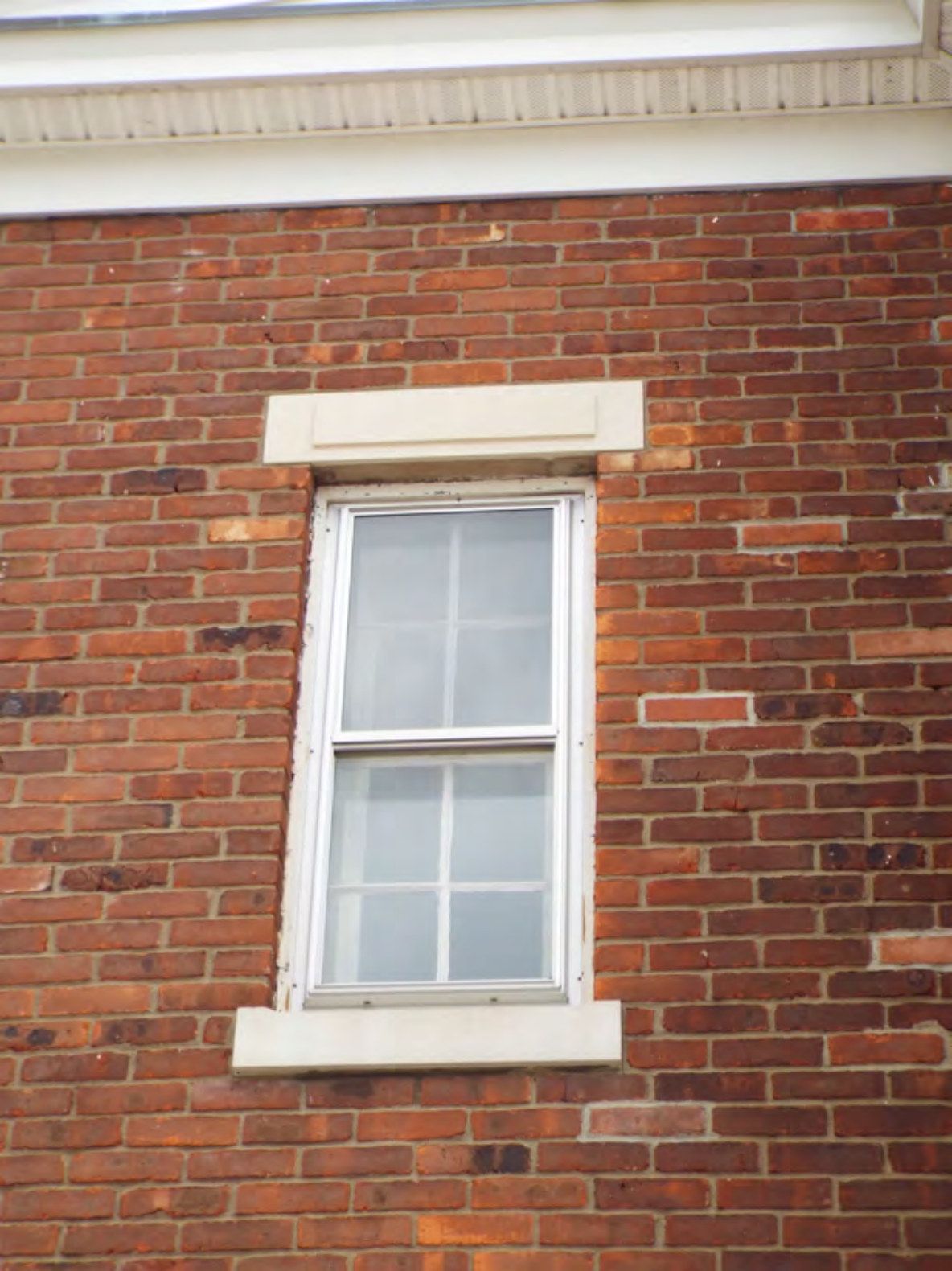 Double-hung sash window with stone lintel and sill.